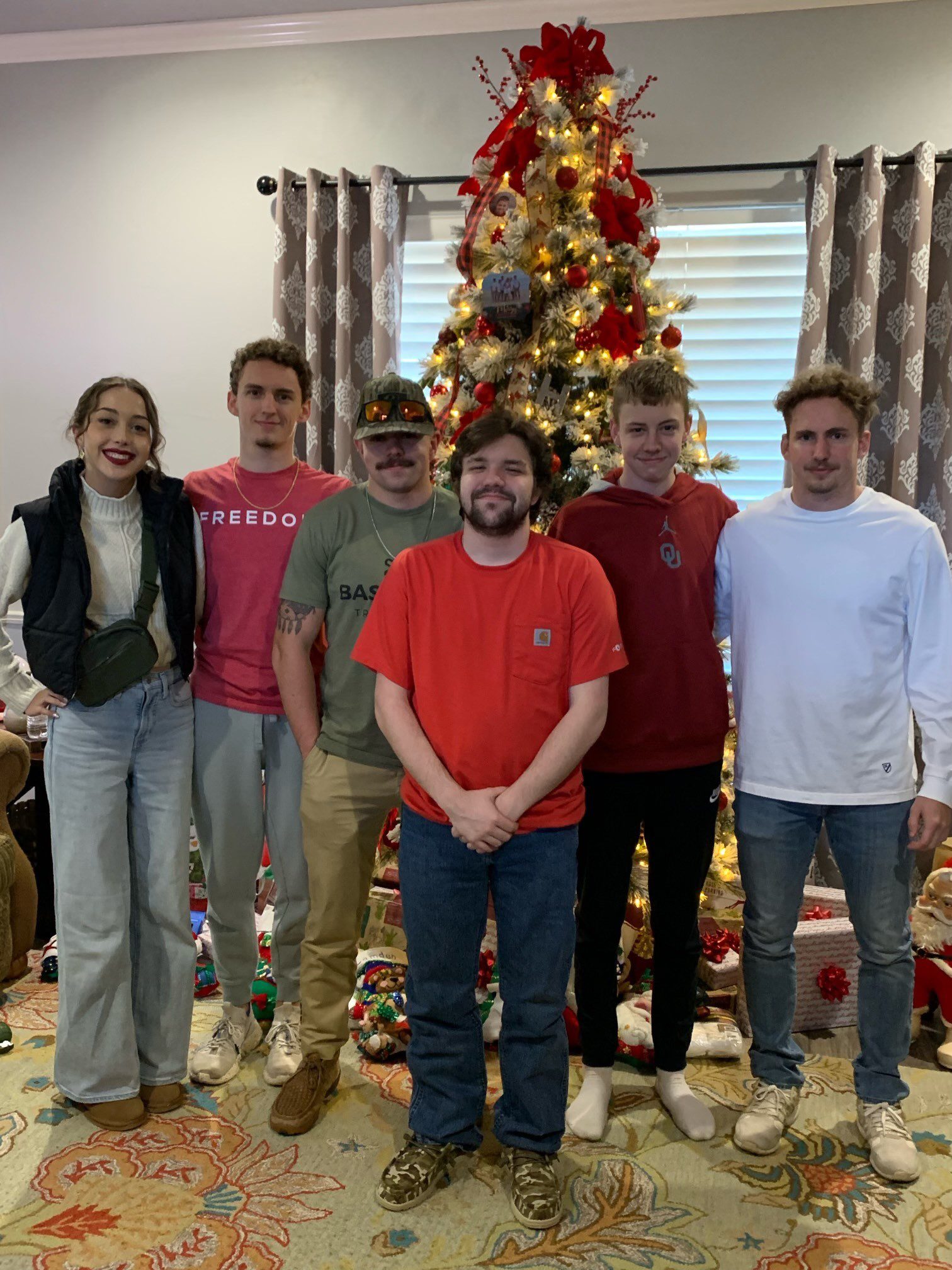 a family posing for a photo with christmas tree